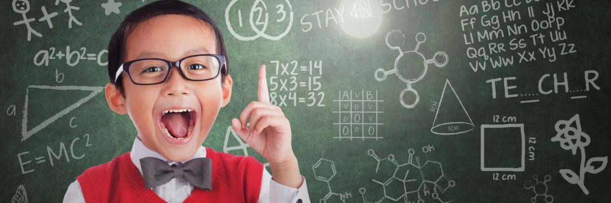 Asian student boy has idea under lit bulb in class with written board